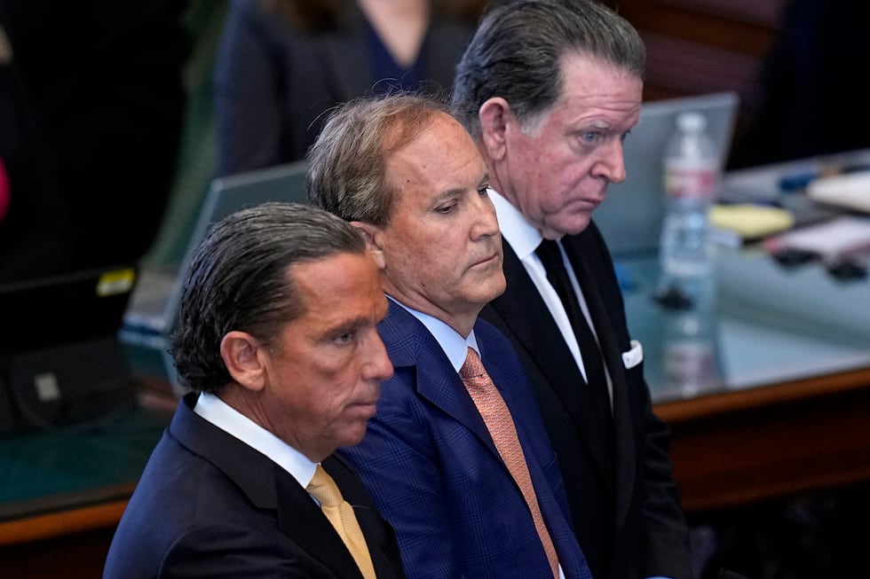 Texas state Attorney General Ken Paxton, center, stands between his attorneys Tony Buzbee,...
