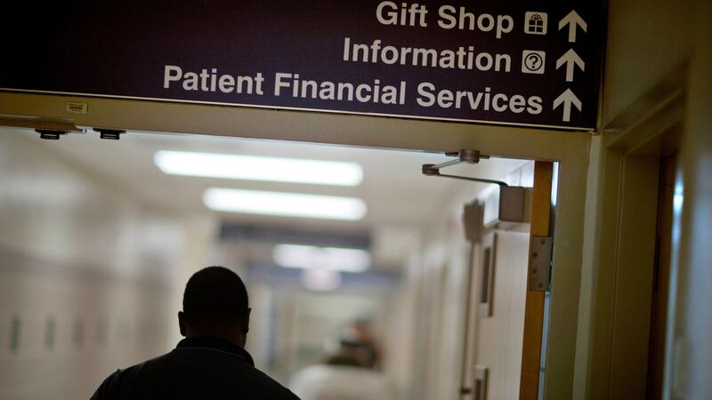 FILE - A sign points visitors toward the financial services department at a hospital, Friday,...